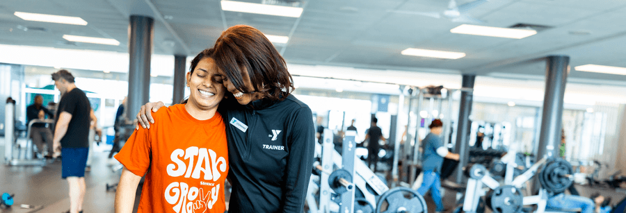 a person hugging another person at the gym in support of their workout